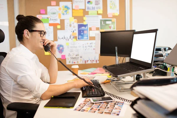 Businessman talking on phone at creative office — Stock Photo, Image