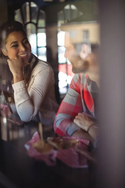 Couple having burger together at restaurant — Stock Photo, Image