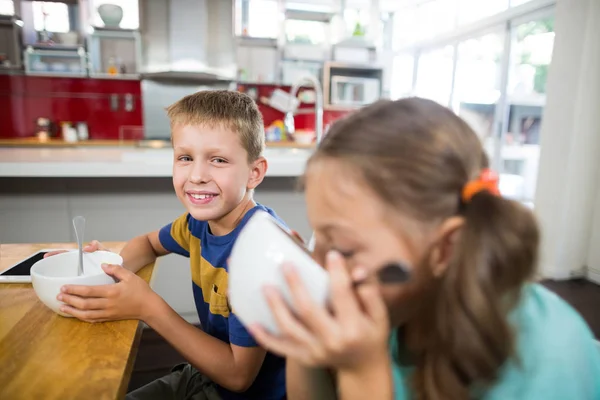 Sibling having breakfast cereal in kitchen — Stock Photo, Image