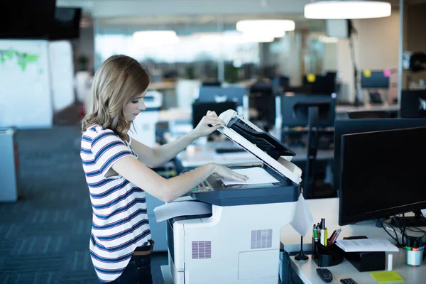 Zakenvrouw kopieermachine gebruiken in office — Stockfoto