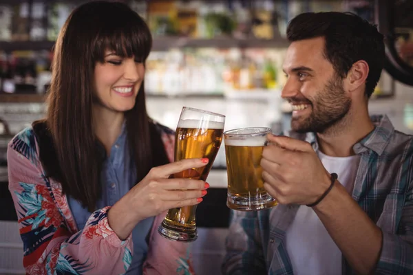 Casal brindar copos de cerveja no balcão — Fotografia de Stock