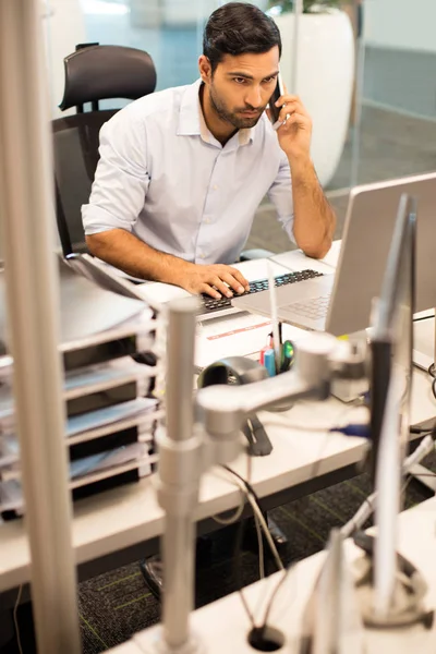 Affärsman prata telefon medan du arbetar — Stockfoto