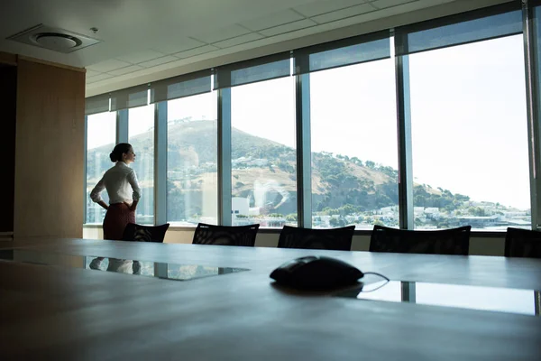 Businesswoman looking through window — Stock Photo, Image