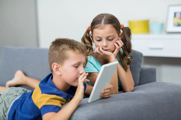Geschwister nutzen digitales Tablet im Wohnzimmer — Stockfoto