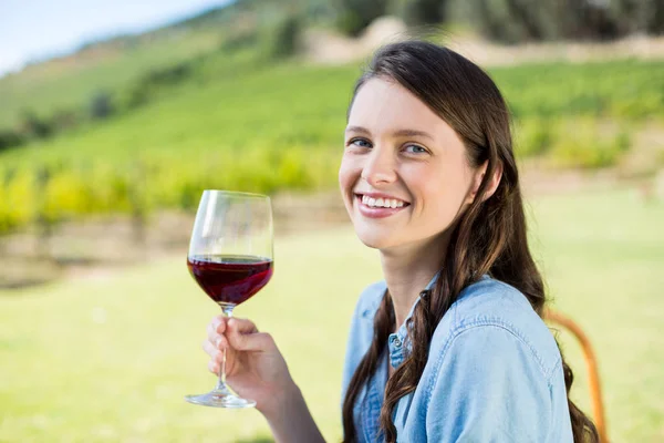 Uśmiechnięta kobieta trzyma wino czerwone — Zdjęcie stockowe