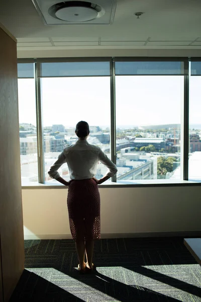 Executivo de negócios feminino olhando através da janela — Fotografia de Stock