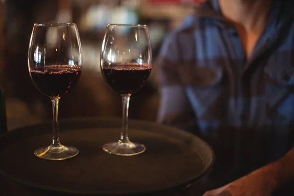 Bandeja de tenencia de bar con copas de vino tinto — Foto de Stock