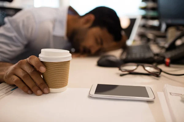 Empresário dormindo enquanto segura café — Fotografia de Stock