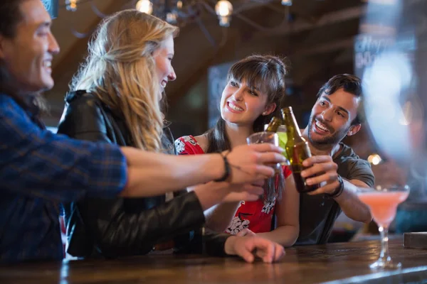 Friends toasting drinks at bar counter — Stock Photo, Image