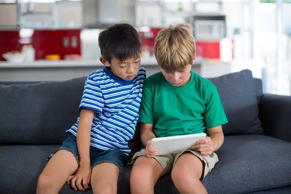 Frères et sœurs utilisant une tablette numérique dans le salon — Photo