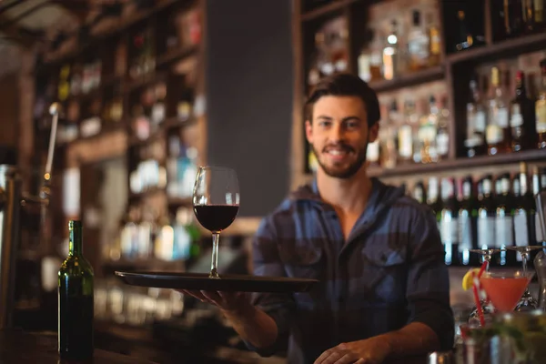 Bar anbud holding bricka med glas vin — Stockfoto