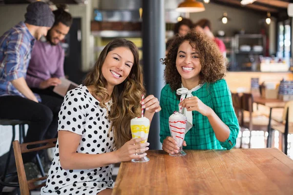 Female friends holding smoothies in restaurant — Stock Photo, Image