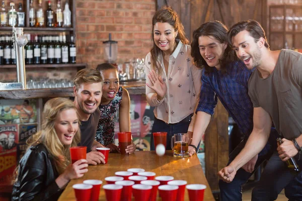 Друзья радуются, когда женщина играет в пив-понг — стоковое фото