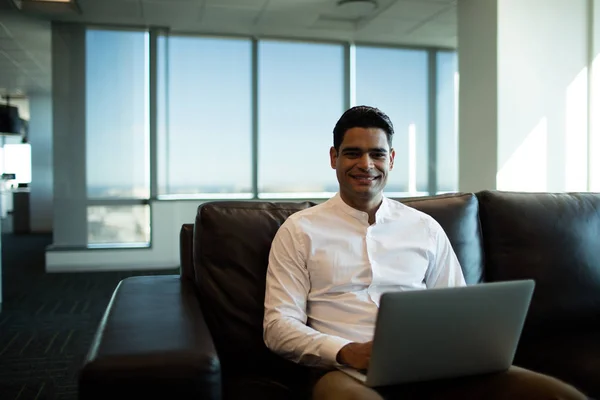 Affärsman med laptop sittande i soffa — Stockfoto