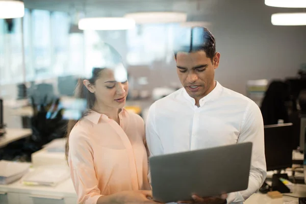 Kollegen diskutieren über Laptop im Büro — Stockfoto