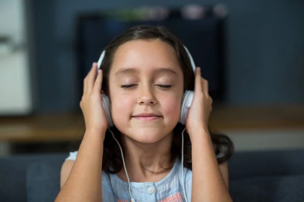 Tyttö kuuntelee musiikkia kuulokkeilla — kuvapankkivalokuva