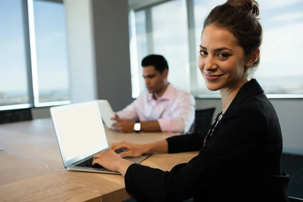 Affärskvinna maskinskrivning på laptop vid bord — Stockfoto