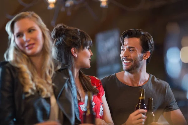 Friends looking at each other while holding beer bottles` — Stockfoto