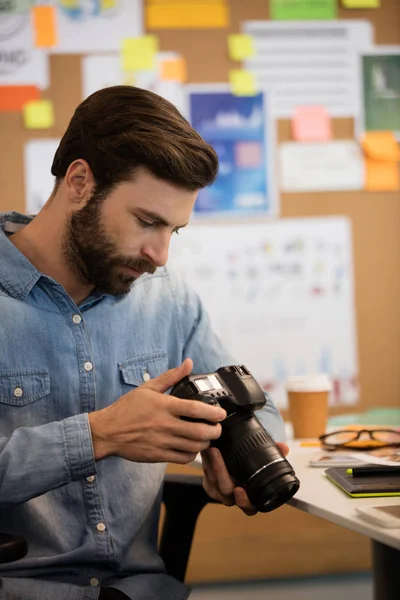 Fotógrafo usando câmera no escritório criativo — Fotografia de Stock