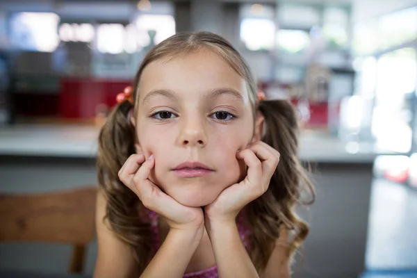 Upset girl looking at camera in kitchen — Stock Photo, Image