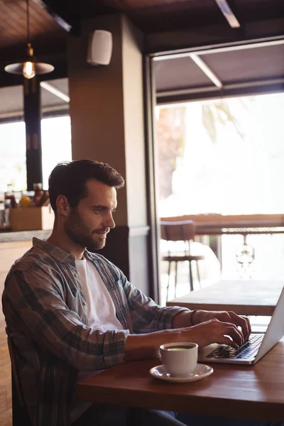 Homme utilisant un ordinateur portable tout en prenant un café — Photo