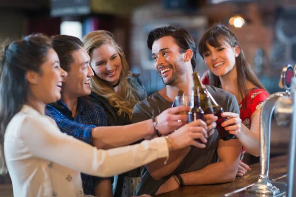 Amigos alegres tostando botellas de cerveza — Foto de Stock