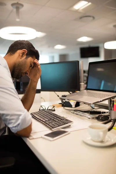 Homme d'affaires tendu assis au bureau — Photo