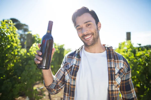 Homme tenant une bouteille de vin au vignoble — Photo