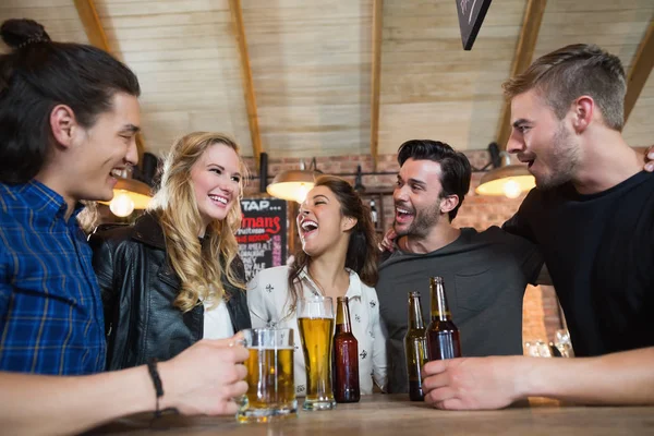 Друзья, стоящие за бокалом пива и бутылками — стоковое фото