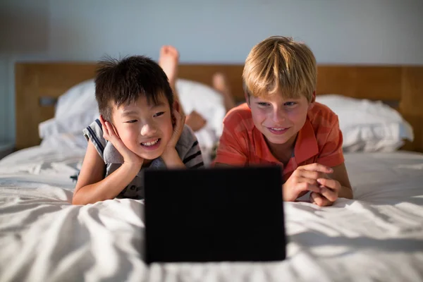 Τα αδέλφια που βλέπουν ψηφιακή δισκίο στο κρεβάτι — Φωτογραφία Αρχείου