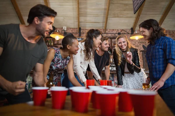 Друзья играют в пиво-понг в баре — стоковое фото