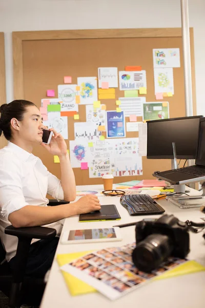 Designer taler på telefon, mens du arbejder - Stock-foto