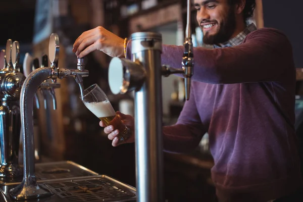 Bar tender filling beer from bar pump — Stock Photo, Image