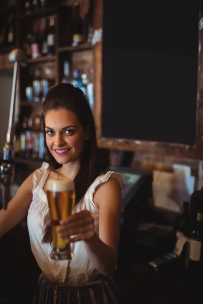 Female bar tender holding glass of beer — Stock Photo, Image