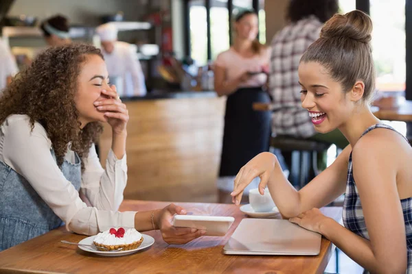 Amis féminins regardant dans la tablette et riant — Photo