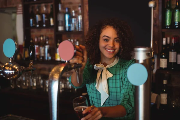 Waitress using beer tap at counter — Stock Photo, Image