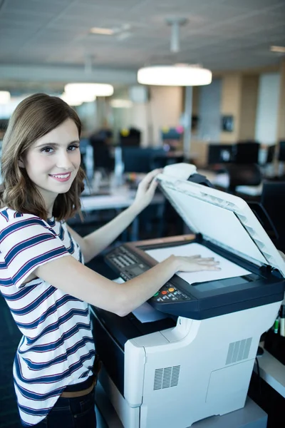 Empresaria usando la máquina de copia en la oficina —  Fotos de Stock
