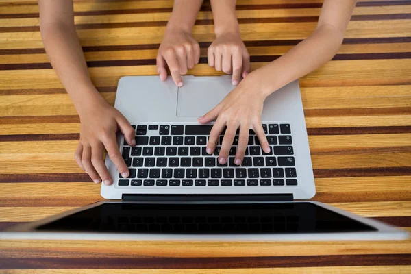 Hand of siblings using laptop in kitchen — Stock Photo, Image