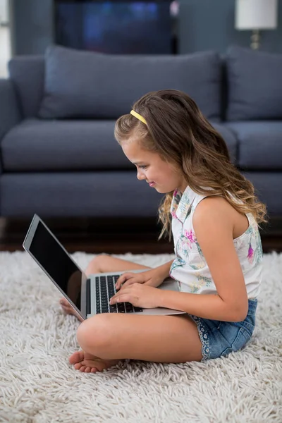 Menina usando laptop na sala de estar — Fotografia de Stock