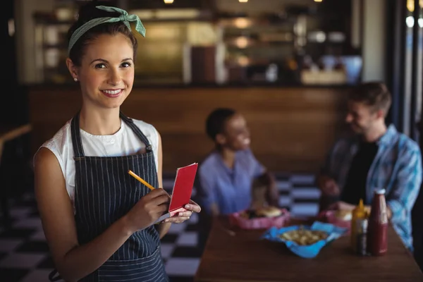 Servitrice tager imod bestilling på restaurant - Stock-foto