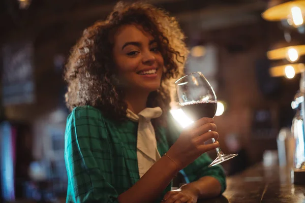 Mulher tomando vinho no balcão do bar — Fotografia de Stock