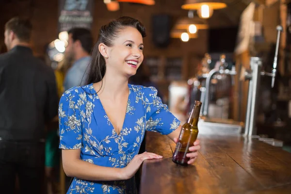 Donna guardando lontano mentre tenendo bottiglia di birra — Foto Stock