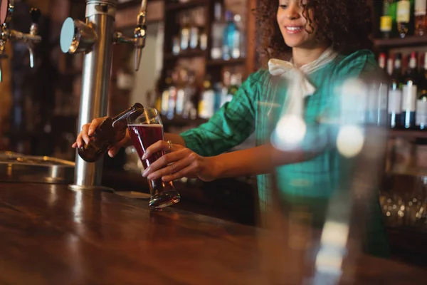 Camarera vertiendo cerveza en vaso pilsner — Foto de Stock