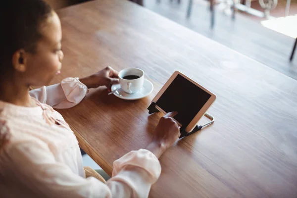 Vrouw met behulp van digitale tablet terwijl het hebben van koffie — Stockfoto