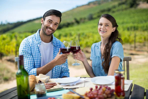 Casal brindar copos de vinho tinto — Fotografia de Stock