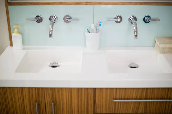 Grifos de fregadero con lavado a mano, cepillo de dientes y pasta de dientes — Foto de Stock