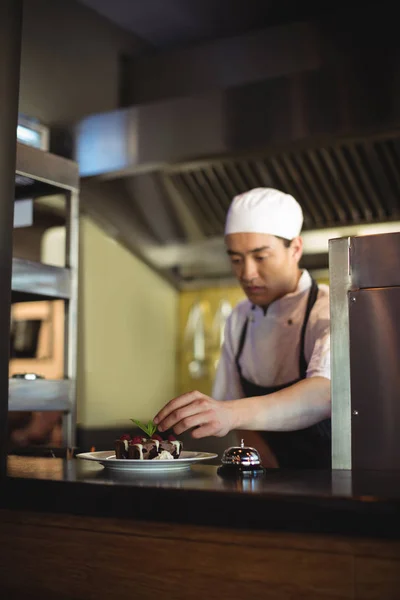 Male chef garnishing dessert plate — Stock Photo, Image