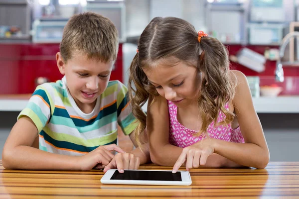 Hermanos usando tableta digital en la cocina — Foto de Stock