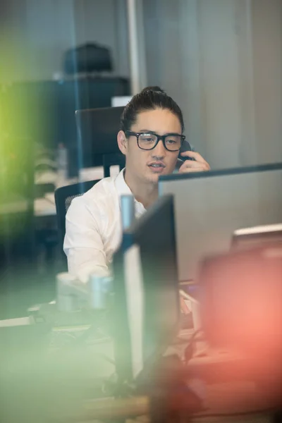 Uomo d'affari che parla al telefono mentre lavora — Foto Stock