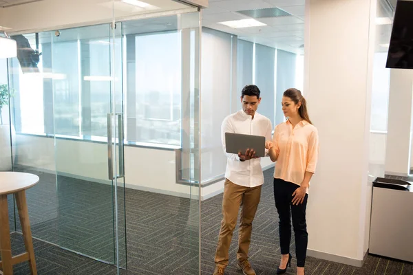 Zakenvrouw met mannelijke collega met behulp van laptop — Stockfoto